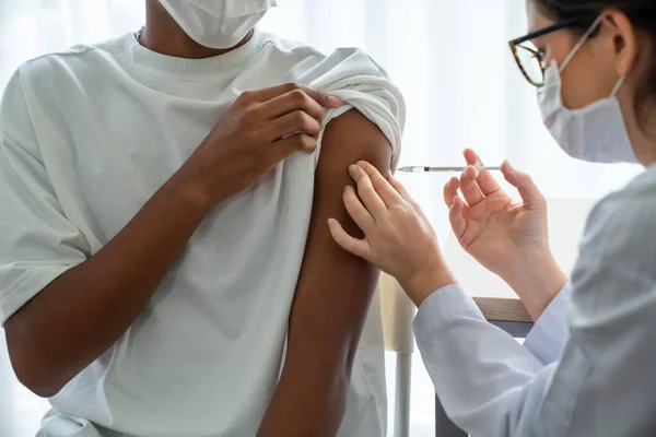 Young man visits skillful doctor at hospital for vaccination