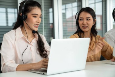 Kulaklık takan iş adamları ofiste aktif olarak çalışıyorlar.