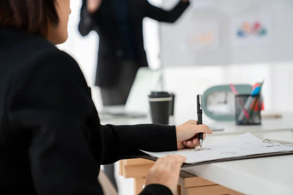 Femme d'affaires en réunion d'affaires écrivant le papier habilement à la salle de bureau . — Photo