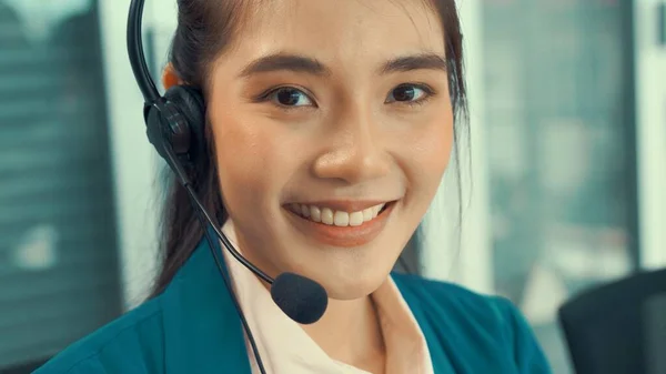 Mulher de negócios usando fone de ouvido trabalhando ativamente no escritório — Fotografia de Stock