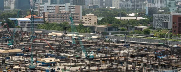 Stor byggeplads med tunge entreprenørmaskiner i metropol - Stock-foto