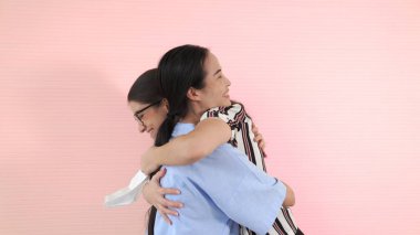 Mutlu arkadaşlar maskesini çıkarıp birbirlerine sıkıca sarılırlar.