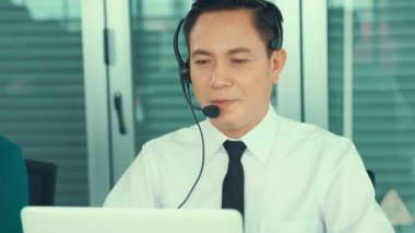 Kulaklık takan bir işadamı aktif olarak ofiste çalışıyor.