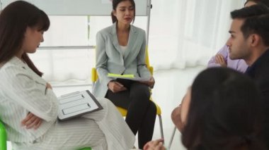 İş adamları daire içinde otururken iş projesini ustaca tartışıyor