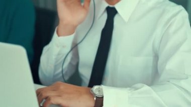 Kulaklık takan iş adamları ofiste aktif olarak çalışıyorlar.