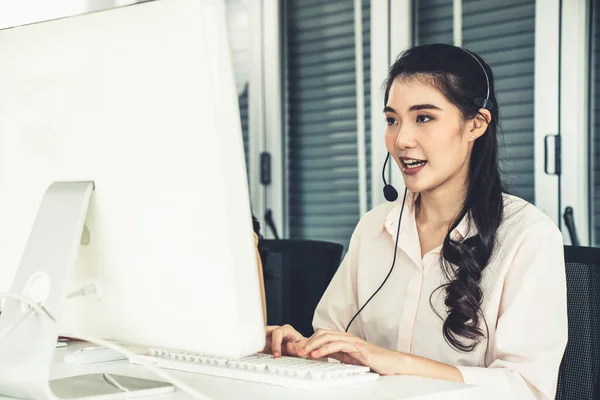 Empresaria con auriculares trabajando activamente en la oficina — Foto de Stock