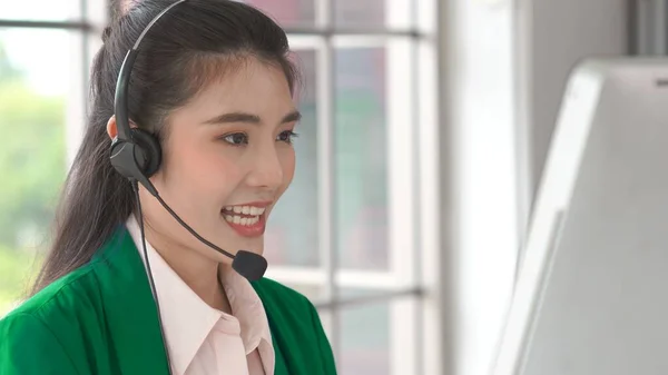 Businesswoman wearing headset working actively in office — Stock Photo, Image