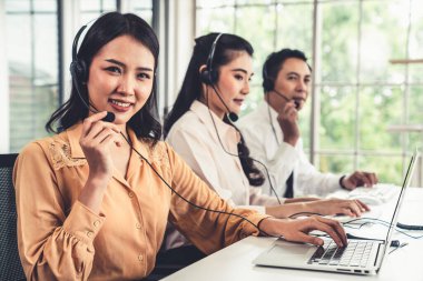 Kulaklık takan iş adamları ofiste aktif olarak çalışıyorlar.