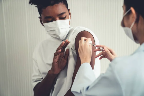 Young man visits skillful doctor at hospital for vaccination