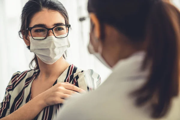 Young woman visits skillful doctor at hospital for vaccination