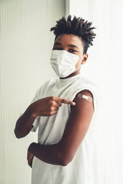 Adolescent afro-américain montrant joyeusement le bandage de vaccin COVID-19 — Photo