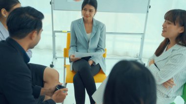 İş adamları daire içinde otururken iş projesini ustaca tartışıyor