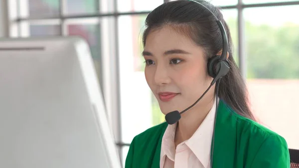 Empresaria con auriculares trabajando activamente en la oficina —  Fotos de Stock