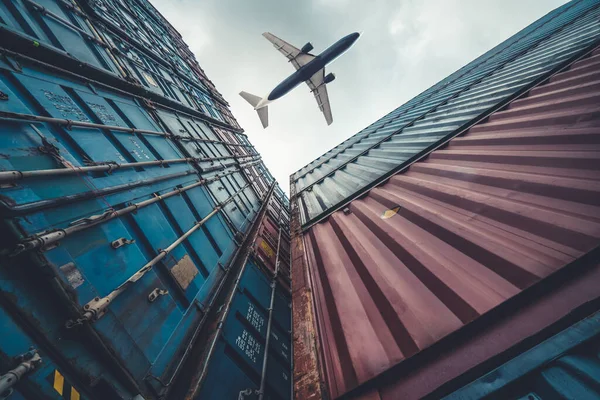 Грузовой самолет, летящий над зарубежными контейнерами — стоковое фото