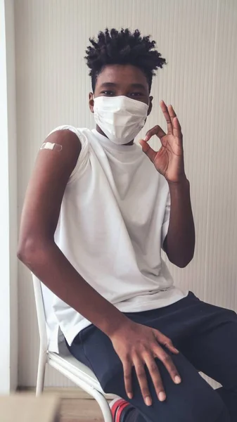 Adolescent afro-américain montrant joyeusement le bandage de vaccin COVID-19 — Photo