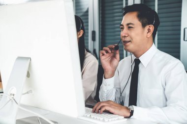 Kulaklık takan bir işadamı aktif olarak ofiste çalışıyor.