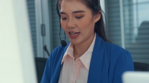 Empresaria con auriculares trabajando activamente en la oficina — Vídeos de Stock