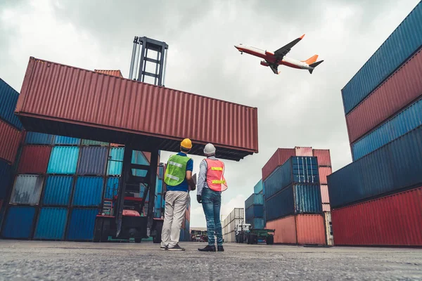 Промышленный рабочий работает с коллегами в зарубежном порту грузовых контейнеров — стоковое фото