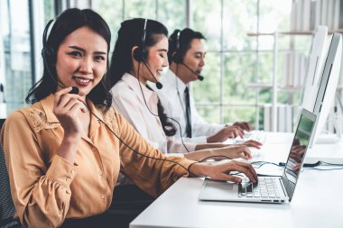 Kulaklık takan iş adamları ofiste aktif olarak çalışıyorlar.