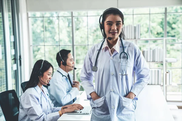 Läkare team bär headset talar aktivt på videosamtal på sjukhus klinik — Stockfoto