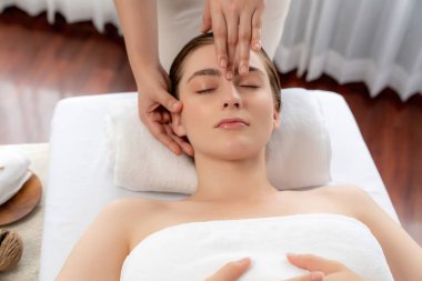 Kafkasyalı kadın stres önleyici kafa masajından ve lüks tatil beldesi ya da otel spa salonundaki modern ışık ortamında yüz güzelliği eğlencelerini şımartmaktan hoşlanıyor. Sessiz.