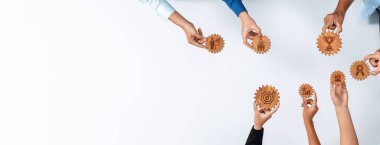 A vibrant display of diverse hands engaged in teamwork, showcasing wooden gears that symbolize strategy and collaborative achievement in a professional setting. Amity