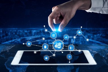 A hand interacts with a tablet displaying a network of KPI icons, symbolizing data analysis and digital innovation in a global business environment. Tessel
