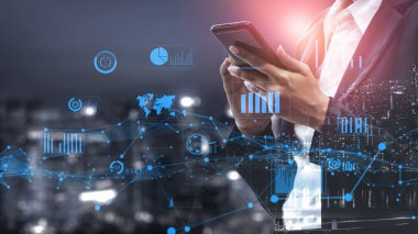 A business professional interacts with a smartphone, showcasing digital data overlays of graphs and charts in a night cityscape, emphasizing modern technology and analytics. Xenic