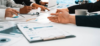 Çeşitli profesyonellerden oluşan bir grup, iş stratejileri ve içgörüleri tartışırken, modern bir ofis masasındaki çizelge ve verileri analiz ederek dinamik bir toplantıya girişiyor. SACTR