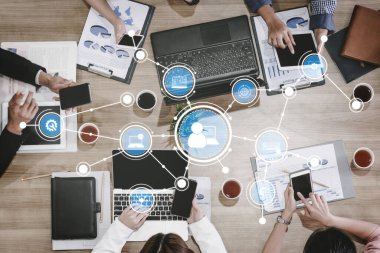 A business team collaborates in a modern office, utilizing various digital devices to enhance communication and networking while focusing on productivity and innovation. Tessel