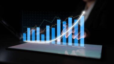 A businessperson reviews digital analytics in a modern workspace. The image features graphs showcasing growth trends and data insights for effective decision-making. Impute