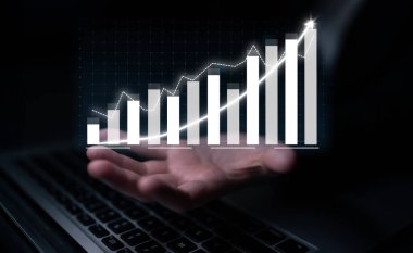 A hand displays a glowing digital graph on a dark background, illustrating growth trends and financial success, aligning with modern data analysis concepts. Impute