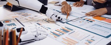 İş yerindeki gelişmiş teknolojiyi tasvir eden eşsiz bir sahne. Robot bir el, insan ekibiyle birlikte detaylı iş verilerini ve stratejilerini analiz ediyor.