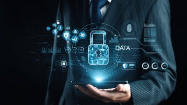Bir işadamı, dijital bir kilit ve veri koruması ve siber güvenlik çözümlerini modern bir bağlamda vurgulayan bir arayüzü içeren bir akıllı telefonu güvenle elinde tutuyor. Dörtgen