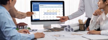 İç mimar tasarımcı grubu, daha kesin tasarım için planlar ve dizüstü bilgisayar ekran mimari yazılımı üzerinde birlikte tartışıyorlar. Modern ev tasarımı ve yenileme. İçgörü