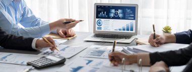 İş zekası ve veri analizi kavramı. Analizci ekibi laptop ekranında finansal veri analizi üzerinde çalışıyor. Etkili iş stratejik planlama için pazarlama göstergesi olarak. İçgörü