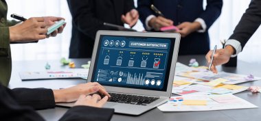 Analizci ekibi yaratıcı ve analitik beyin fırtınası fikri için bilgisayar ekranında BI veri paneli olan yapışkan bir not kullanıyor. Pazarlama stratejisi için finansal veri görselleştirme teknolojisini analiz et. Dahi.