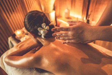 Beyaz kadın müşteri stres önleyici spa masajının keyfini çıkarıyor ve lüks otel ya da otelde sıcak mum ışığında güzellik teniyle eğleniyor. Sessiz.