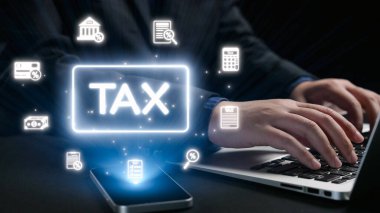 Dijital vergi simgeleriyle çevrili bir dizüstü bilgisayara, modern mali yönetimi ve günlük hayattaki verimli vergi hazırlığının önemini simgeleyen bir kişi yazı yazar. Dörtgen