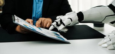 Bir robotik el iş toplantısı sırasında insanlarla etkileşime girer, teknolojinin iş yeri dinamikleri ve işbirlikçi stratejilere entegrasyonunu gösterir. Noogenesis