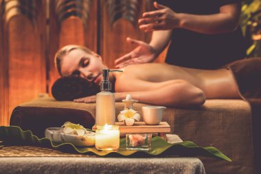 Aromaterapi masajı ambiyansı ya da spa salonu kompozisyon düzeneği bulanık kadınlara odaklı dekor mumları ve spa aksesuarları ile tatil köyü veya otel arka planında keyifli aroma spa masajı yapan. Sessiz.