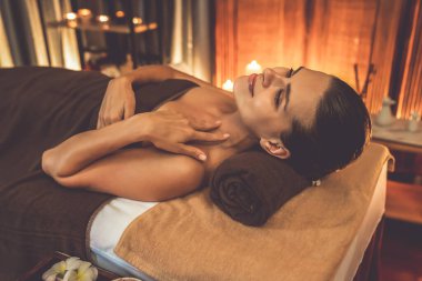 Beyaz kadın müşteri stres önleyici spa masajının keyfini çıkarıyor ve lüks otel ya da otelde sıcak mum ışığında güzellik teniyle eğleniyor. Sessiz.