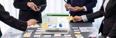 Analizci ekibi yaratıcı ve analitik beyin fırtınası fikri için bilgisayar ekranında BI veri paneli olan yapışkan bir not kullanıyor. Pazarlama stratejisi için finansal veri görselleştirme teknolojisini analiz et. Dahi.