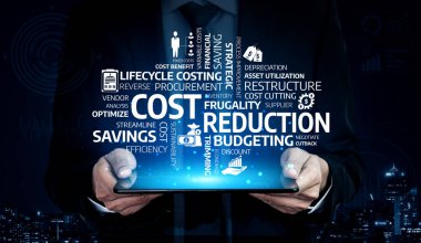 Bir işadamı, dinamik dijital grafiklerle temsil edilen, şehrin ufuk çizgisi zeminine karşı maliyet azaltma ve bütçe azaltma konseptlerini gösteren bir tablet sunuyor. Tessel