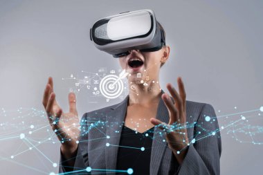 Sanal gerçeklik kulaklığı takan bir iş adamı, modern pazarlama çözümleri ve seyirci katılımını sergilemek için mükemmel olan dijital unsurlarla etkileşime girerken heyecanını dile getiriyor. XDMCP