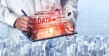 Odaklanmış profesyonel yazılar, veri analizi anahtar kelimeleriyle kaplı bir tablet üzerine yazılmıştır, iş dünyasındaki modern teknoloji entegrasyonunu sembolize eder, şehir zeminine karşı kurulmuştur. Tessel