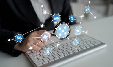 Bir iş adamı dijital ağ grafikleri kullanarak veri analizi yapar ve bu da şık bir ofis ortamında bilgisayar klavyesinde gösterilen bağlantıları ve bilgileri gösterir. Crux