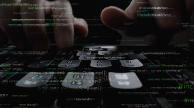 Karanlık bir ortamda gizlenmiş bilgisayar kodları içeren bir klavyeye yazarak teknoloji ve programlamanın özünü gözler önüne seren ellerin yakın çekimi. Xenic
