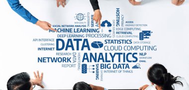 Çeşitli profesyonellerden oluşan bir grup, veri analiziyle ilgili kelimelerle dolu bir masa üzerinde işbirliği yaparak, teknoloji ve sezgilerde modern teknikler sergiliyor. Dostluk