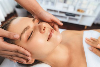 Kafkasyalı kadın stres önleyici kafa masajından ve lüks tatil beldesi ya da otel spa salonundaki modern ışık ortamında yüz güzelliği eğlencelerini şımartmaktan hoşlanıyor. Sessiz.